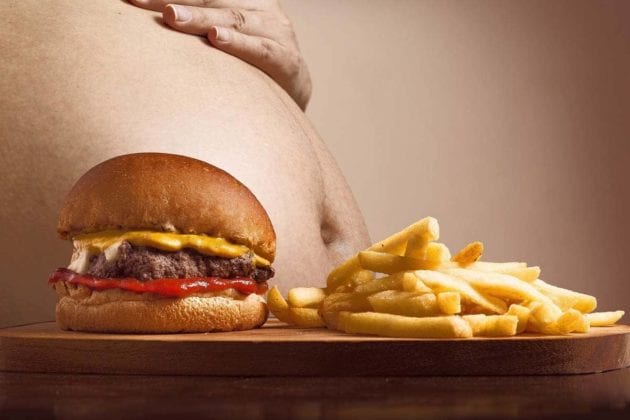 Ein fettleibiger Bauch mit starkem Übergewicht vor Fast-Food-