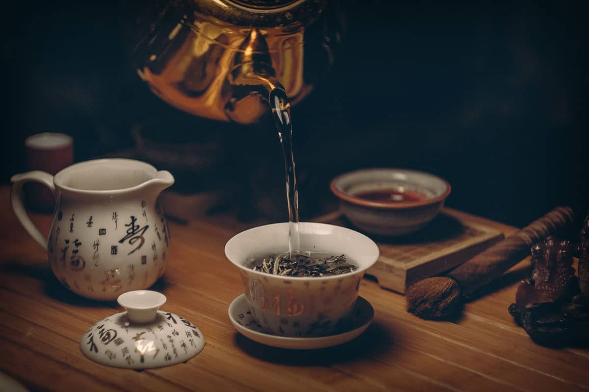 Grüner Tee wird in eine chinesische Teetasse gegossen, damit er ziehen kann