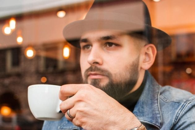 Ein Mann trinkt Kaffee und fragt sich, ob der Kaffee gut für seine Leber ist.