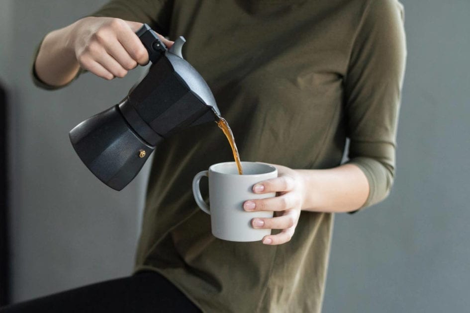 Eine Frau schüttet sich Kaffee ein und fragt sich, ob Kaffee beim Abnehmen hilft